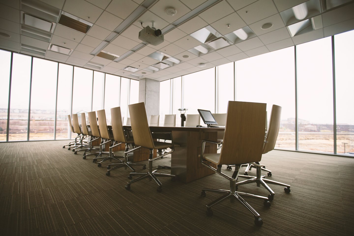 Modern conference room with long table and chairs.