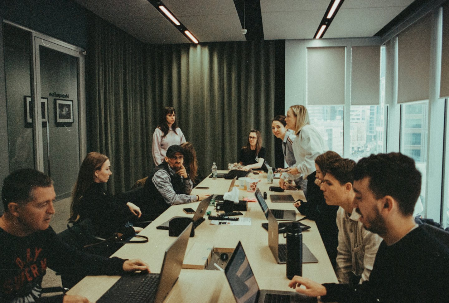 Professionals discussing ideas around a wooden table in an office.